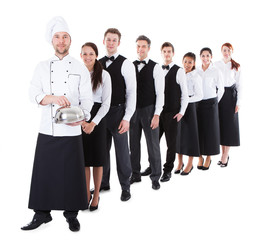 Large group of waiters and waitresses standing in row
