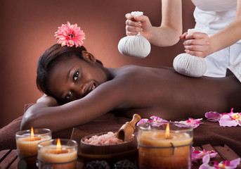 Obraz na płótnie Canvas Woman Enjoying Herbal Massage At Spa