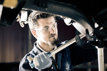 Handsome car mechanic at work