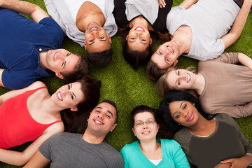 Portrait Of Confident College Students Lying On Grass