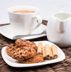 coffee and milk with chocolate cookies and wafer rolls