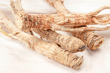 Dried ginseng on the wooden background.