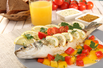Delicious grilled fish on plate on table close-up