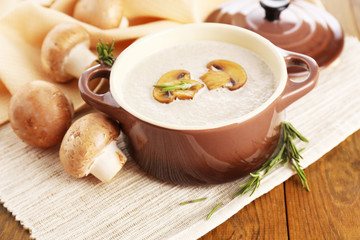 Obraz na płótnie Canvas Mushroom soup in pot, on wooden background
