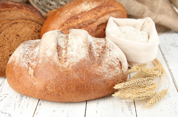 Rye bread with flour on table on sackcloth background