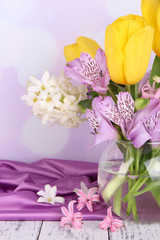 Flowers in vase on table on bright background