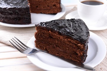Delicious chocolate cake on plate on table close-up