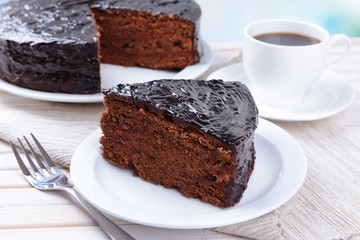 Delicious chocolate cake on plate on table close-up