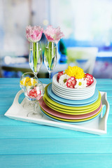 Stack of colorful ceramic dishes and flowers,