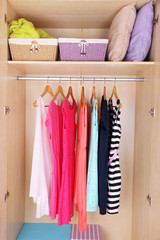 Female clothes on hangers in wardrobe