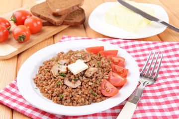 Boiled buckwheat on plate on table close-up