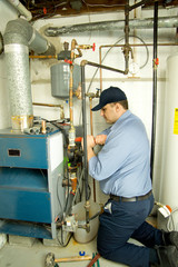 Plumber fixing gas furnace