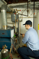 Plumber fixing gas furnace