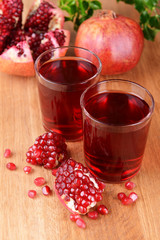 Ripe pomegranates with juice on table close-up