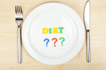 Plate with inscription diet on wooden table close-up