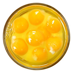 Raw Eggs in Glass Bowl Over White