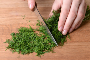 Chopped dill on wooden board close-up