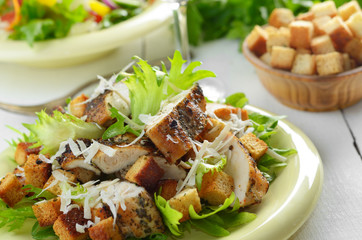 Caesar chicken salad on white table