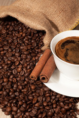 Coffee beans in burlap sack and cup of coffee