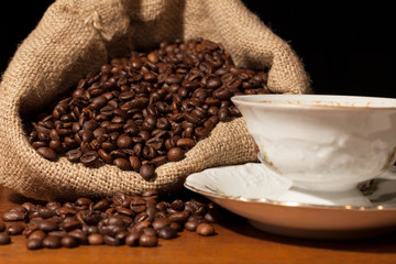 Coffee beans in burlap sack against dark background