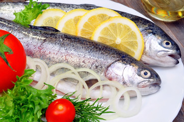 two rainbow trout with lemon and fresh vegetables