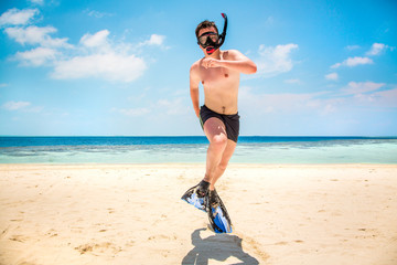 Funny man jumping in flippers and mask.