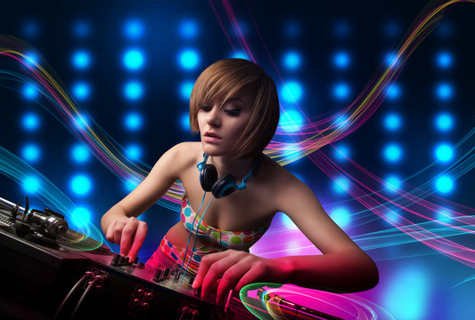 Young Dj girl mixing records with colorful lights