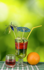 cocktail and orange on green background