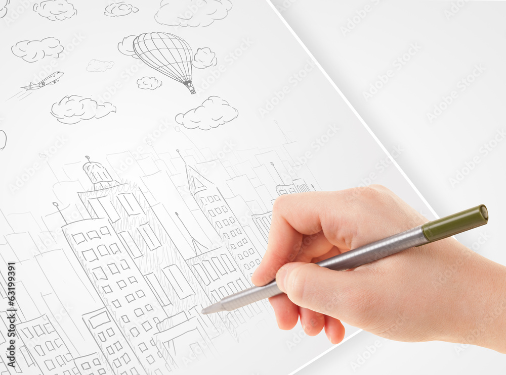 Fototapete A person drawing sketch of a city with balloons and clouds on a