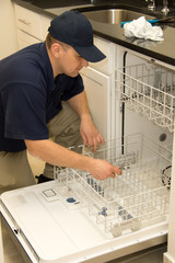 Plumber fixing dishwasher