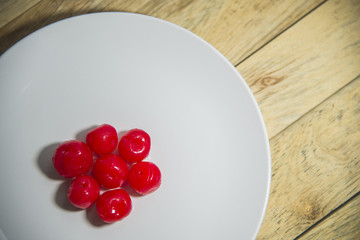 Group of red cherry on  white plate