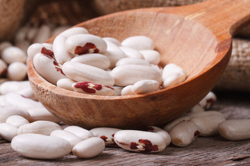 white beans with red spots in the wooden spoon