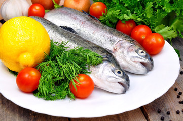 two rainbow trout with lemon and fresh vegetables