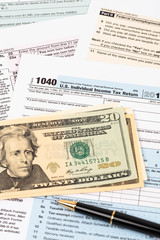 Tax form with pen, and dollar banknote taxation concept