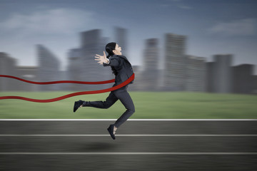 Businesswoman crossing the finish line
