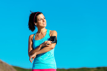 Sporty woman with smartphone armband and earphones