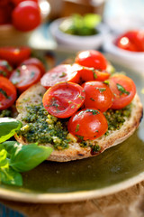 Bruschetta with fresh cherry tomatoes and herb pesto