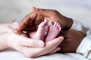 Pieds de bébé entre les mains de ses parents