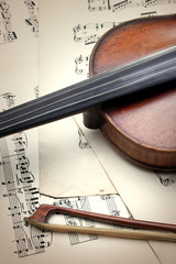 Detail of old scratched violin on music sheet. Vintage style.