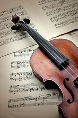 Naklejka na ściany i meble Old scratched violin on music sheet. Vintage style.