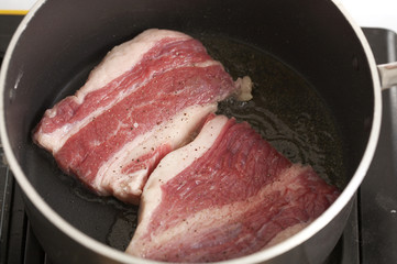 fry beef with olive oil in black pan