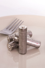 isolated of old AA battery in food dish is energy consumption co