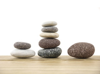 Fototapeta na wymiar Three stacked stones on a wood board