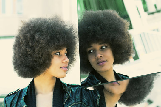 Young black woman looking in to a mirrow