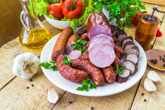 plate various kinds sausages surrounded greens