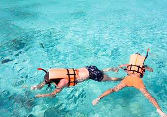 snorkeling in clean water over coral reef