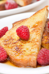 delicious French toast with raspberries and maple syrup, closeup