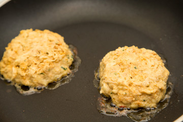 Two Fresh Crab Cakes Cooking in Oil