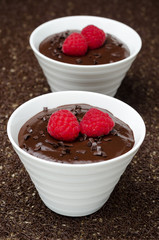 two bowls of chocolate mousse and raspberries