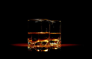 Two glasses of whiskey isolated on black